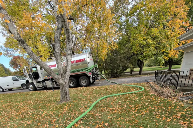 Fall service call — hose curving from truck across the yard