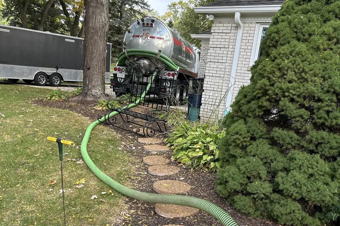 Hose laid carefully through landscaping during a pump-out