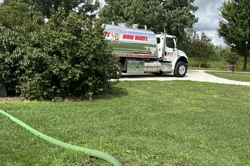 Truck and hose on a tidy summer lawn during a pump-out